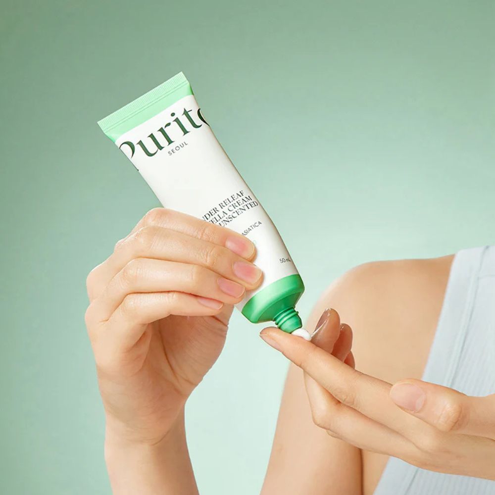 Main appliquant la PURITO Wonder Releaf Centella Cream Unscented sur le doigt.