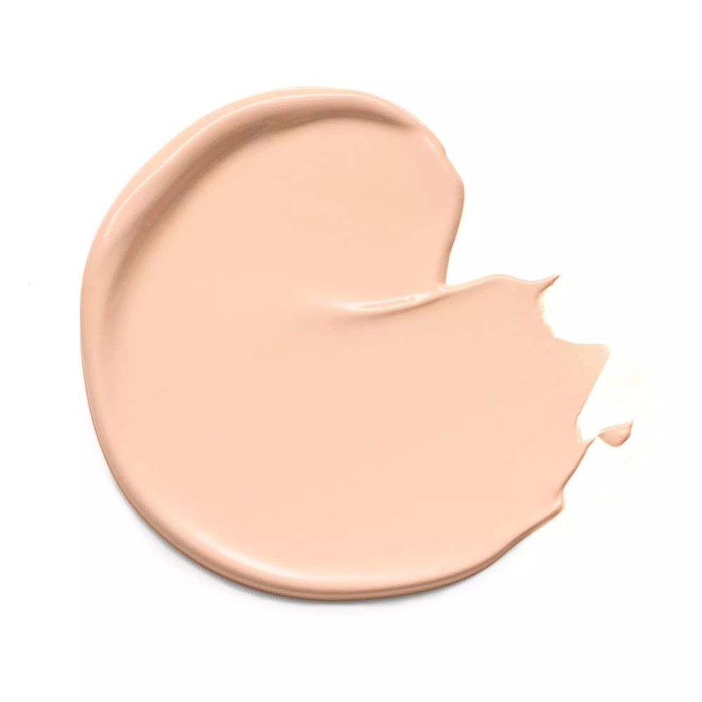 Tache de correcteur clair sur fond blanc. Texture crémeuse, teinte claire.