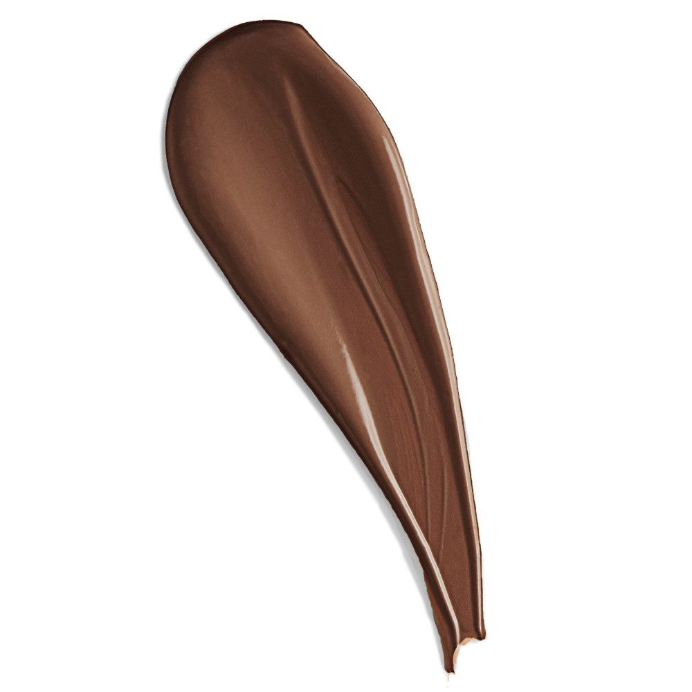 Donkerbruine concealer-veeg op witte achtergrond. Textuur zichtbaar.