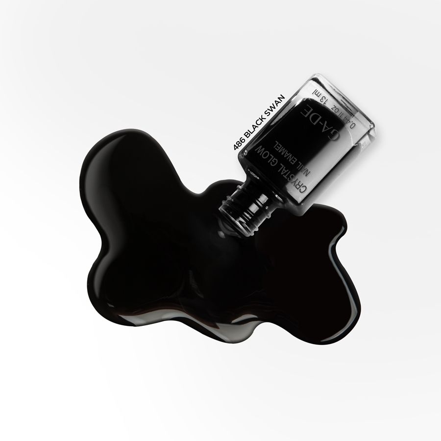 Vernis à ongles noir renversé d'un flacon. Des informations sur le produit et le nom de la marque sont visibles sur le flacon.