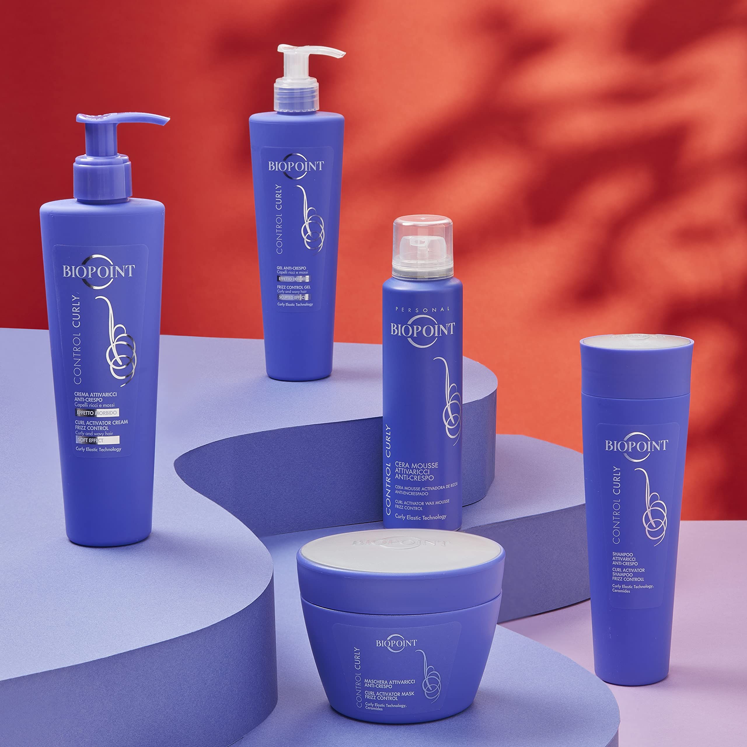 Plusieurs produits Biopoint pour cheveux bouclés. Flacons et pots violets de différentes formes et tailles, sur socles.