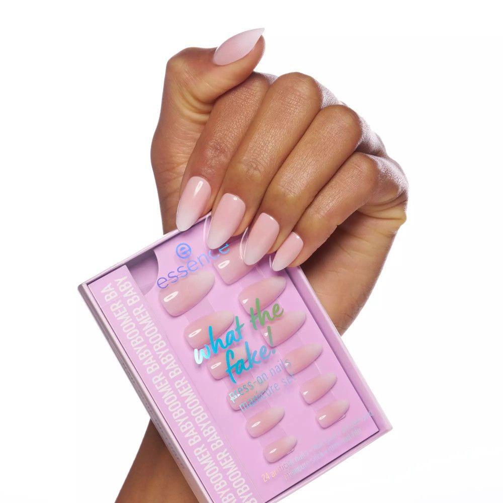 Main avec faux ongles Babyboomer. Dégradé de rose. Emballage avec nom du produit et marque Essence.