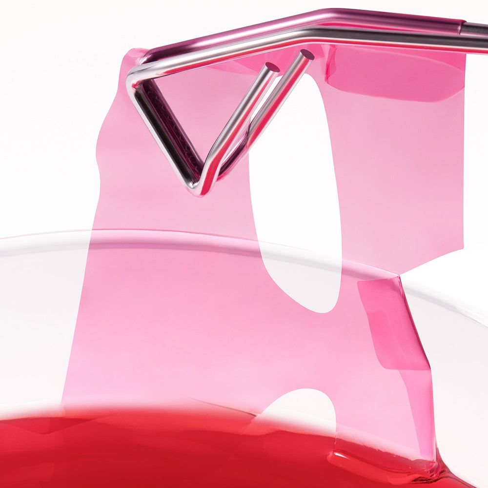 Roze, doorschijnend object met zilverkleurig metalen frame en rode vloeistof.