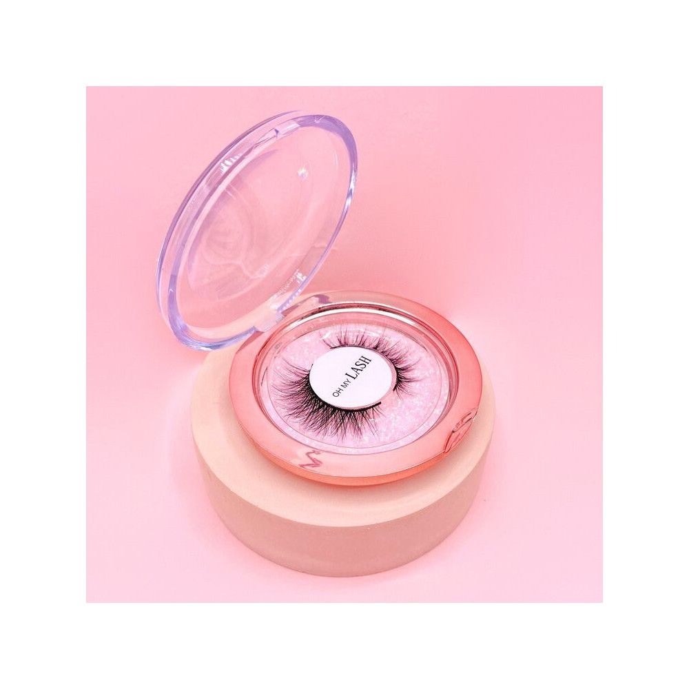 Boîte de rangement ronde rose avec faux cils. Couvercle ouvert. Inscription 'Oh My Lash'.
