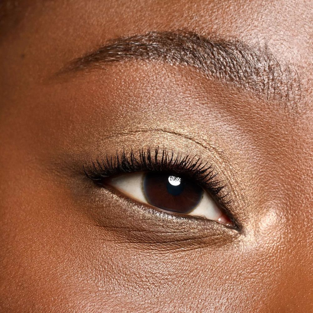 Gros plan d'un œil avec du fard à paupières crème brun.