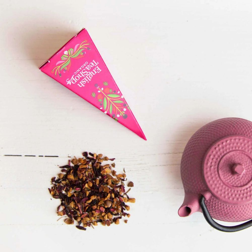 Roze piramidebox en theepot met losse thee. Opschrift: English Tea Shop Organic. Theezakje met opschrift Earl Grey.
