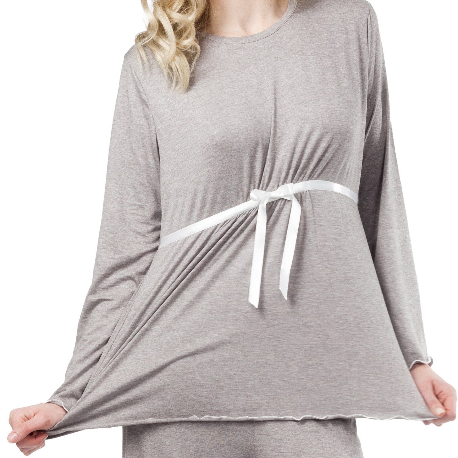 Haut de pyjama de grossesse gris. Manches longues, ruban blanc. Femme tenant le tissu. Ourlet blanc.