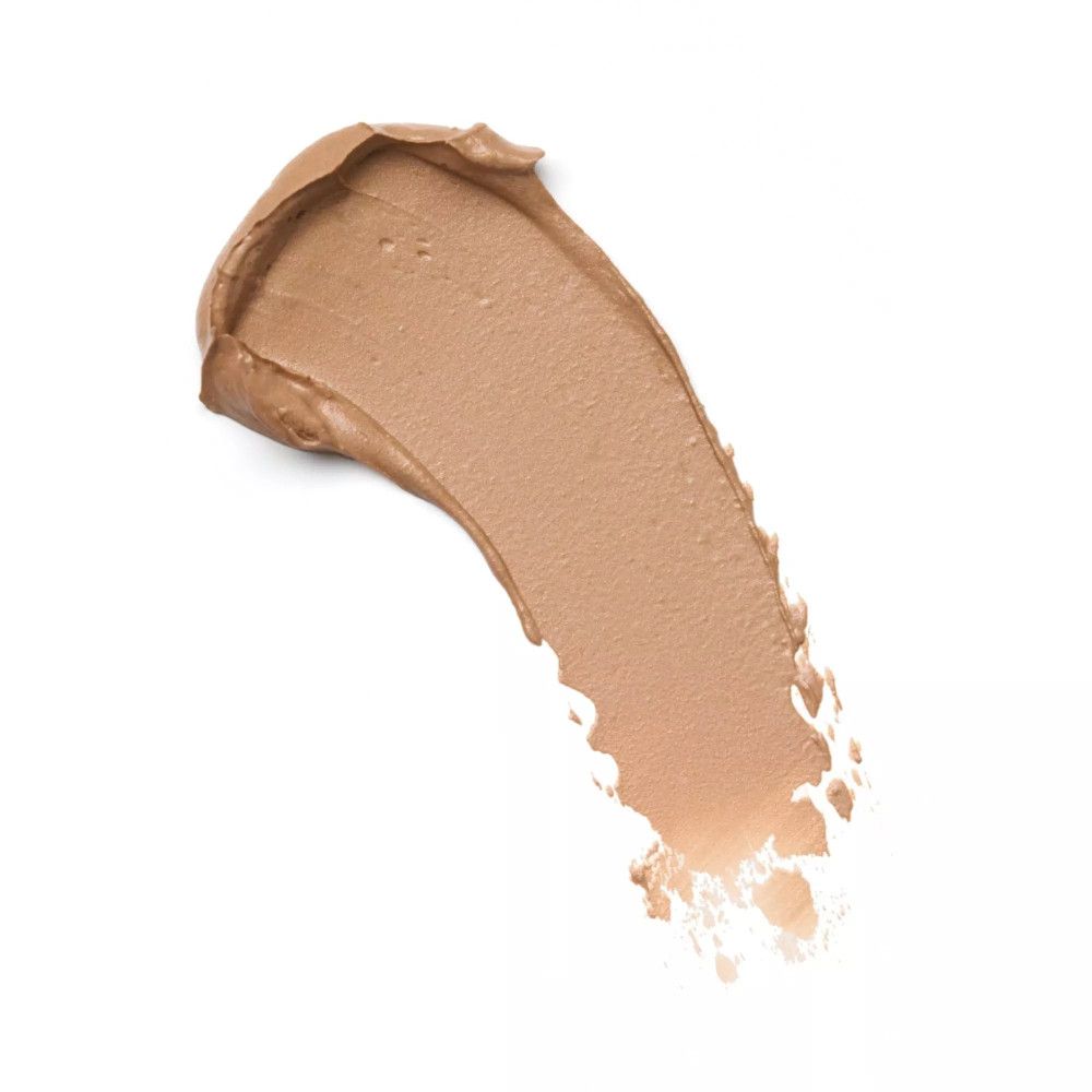 Uitgesmeerd product. Beige crème op witte achtergrond. Textuur en kleur van het product zijn zichtbaar.