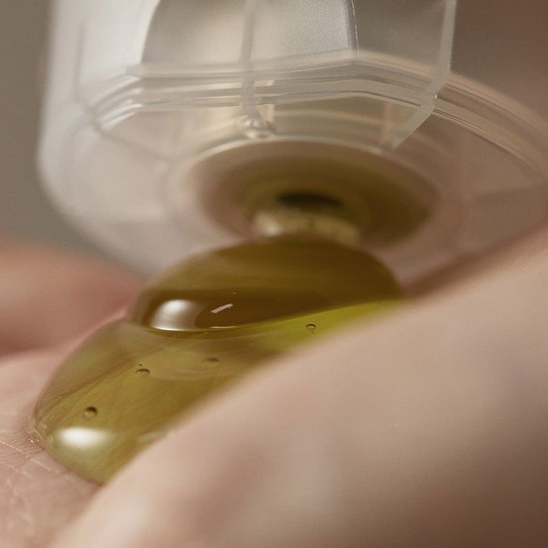 Close-up: gel uit transparante sluiting op hand. Gelige vloeistof.