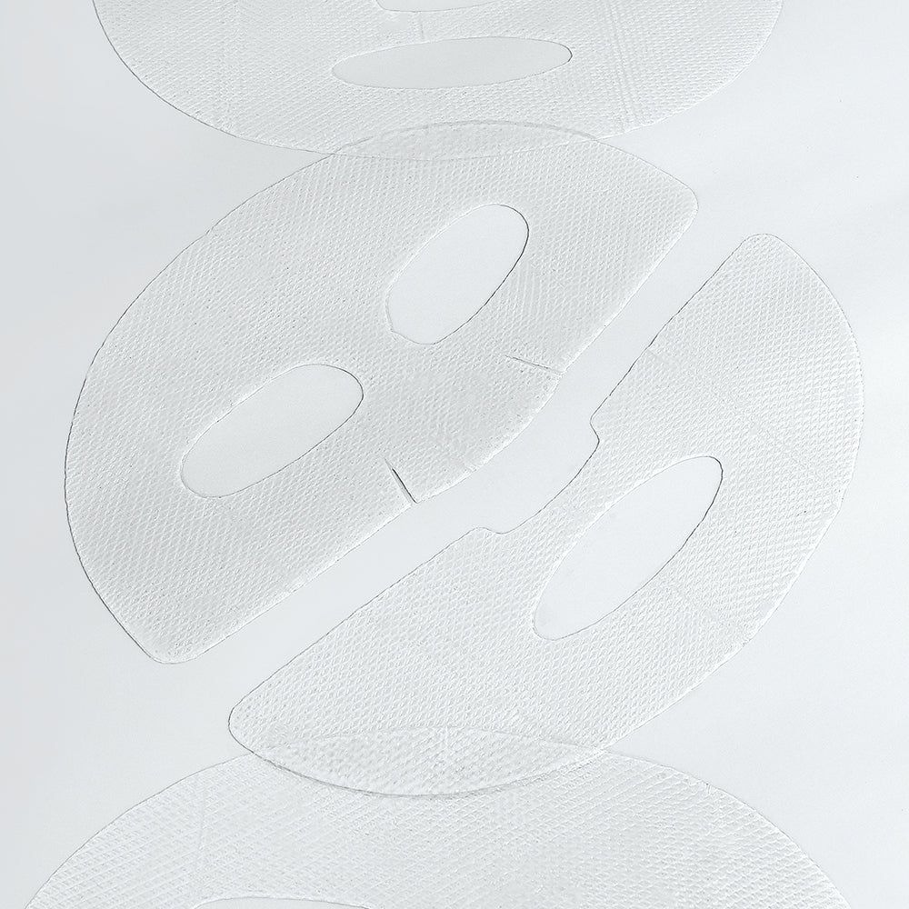 Gros plan de trois masques faciaux blancs avec ouvertures pour les yeux et la bouche.