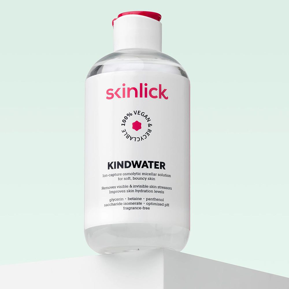 Bouteille de SKINLICK Kindwater eau micellaire sur un piédestal. Liquide transparent.