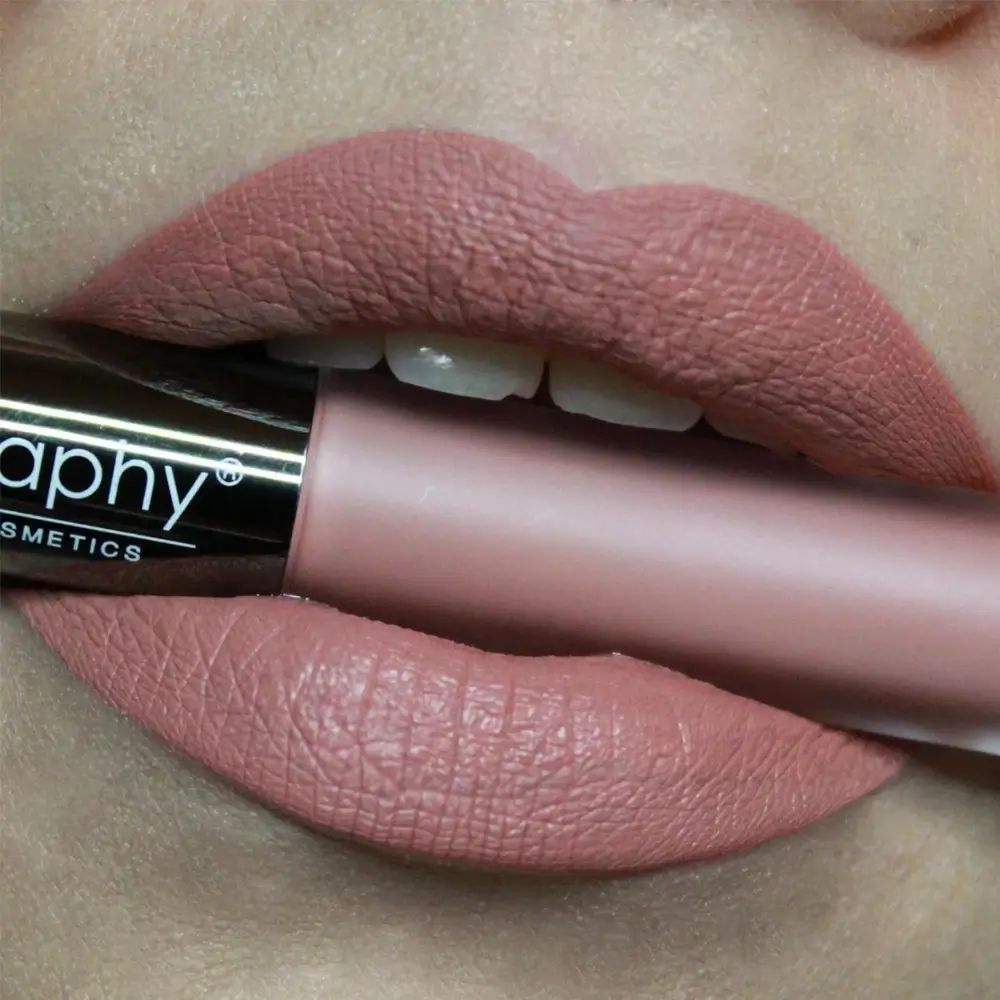Mond met aangebrachte roze-bruine lipstick. Lipstickfles in de mond. Merk BODYOGRAPHY.
