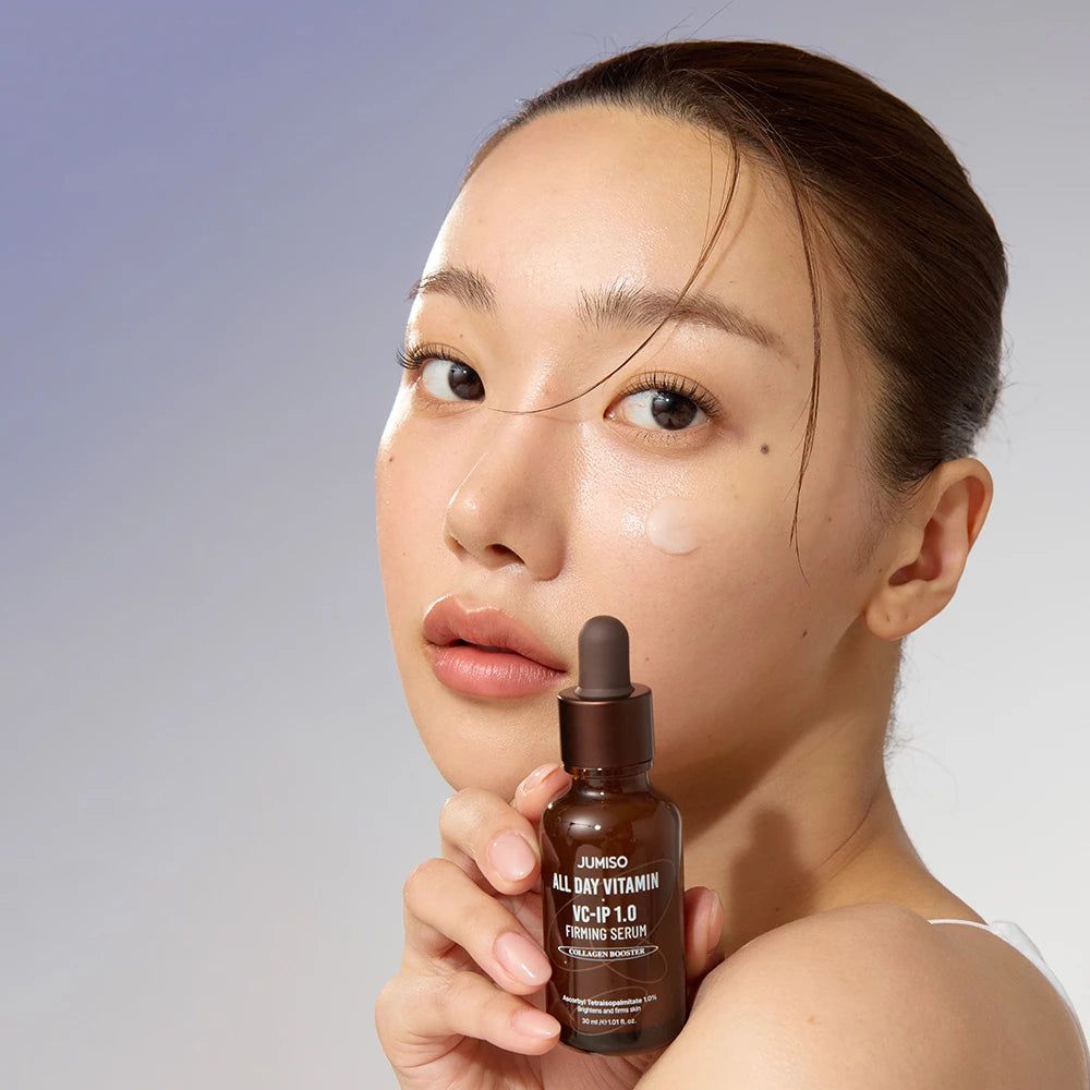 Vrouw met JUMISO All Day Vitamin VC-IP 1.0 Firming Serum fles, aanbrengend op haar huid.