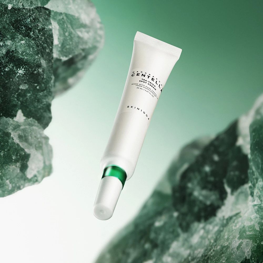 Witte tube met groene applicator, op groene achtergrond. Tekst: MADAGASCAR CENTELLA, TEA-TRICA SPOT CREAM.