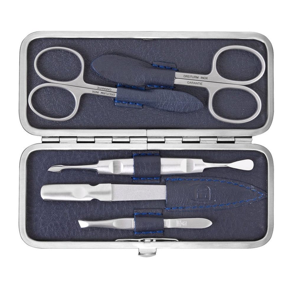 Manicure-etui met zilverkleurige gereedschappen. Schaar, vijl en andere instrumenten. Blauwe lederen voering. Open.