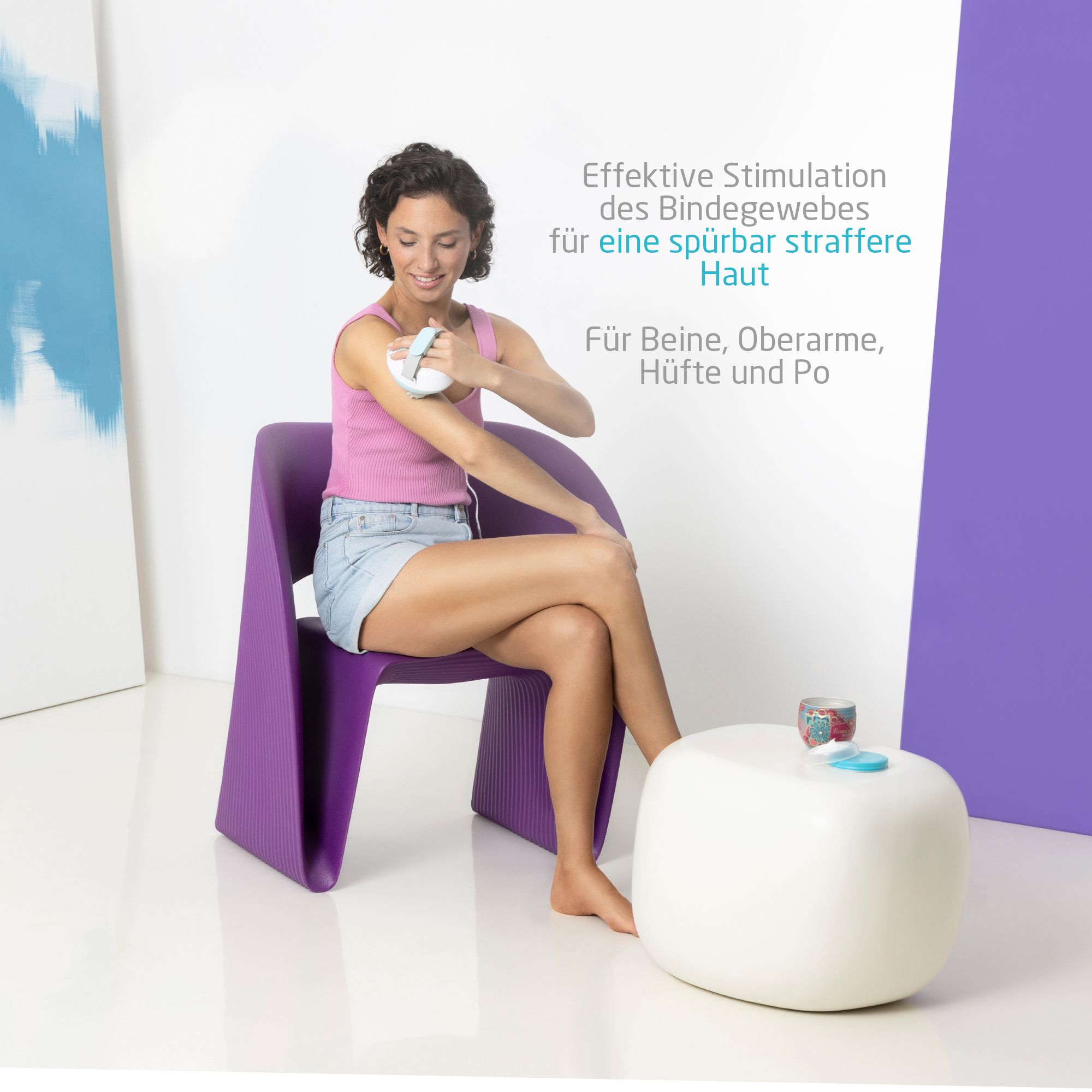 Een vrouw gebruikt een massageapparaat op haar arm, zittend op een stoel.