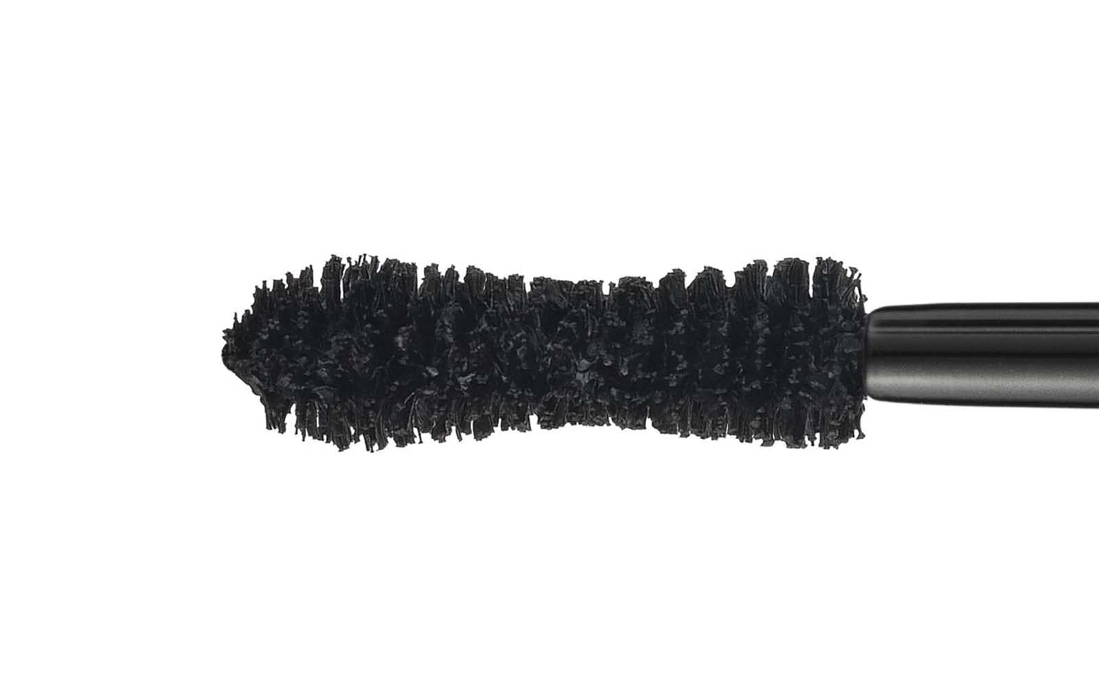 Gros plan d'une brosse de mascara. Soies noires, forme cylindrique.