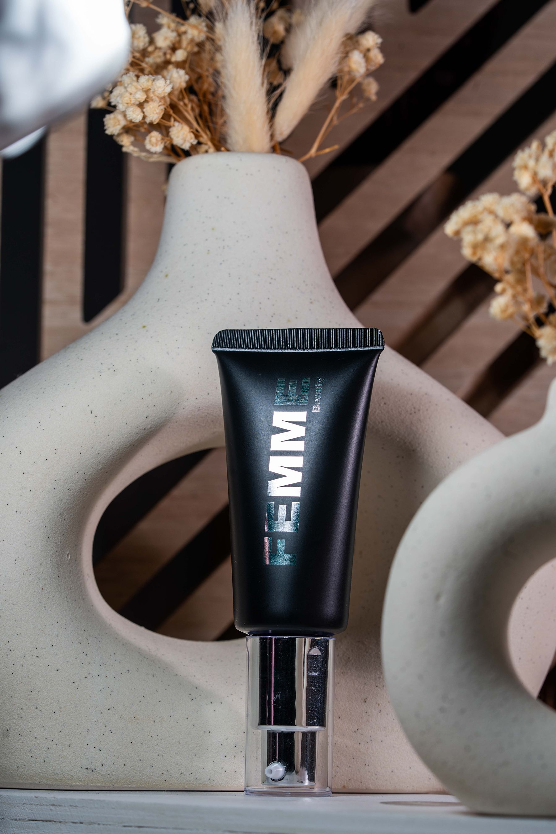 FEMME Intense Hide Concealer dans un tube noir avec distributeur argenté.