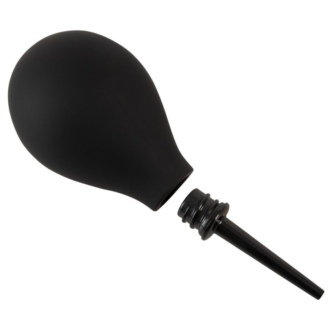 Poire à lavement noire, démontée. Corps en forme de poire, embout conique séparé.