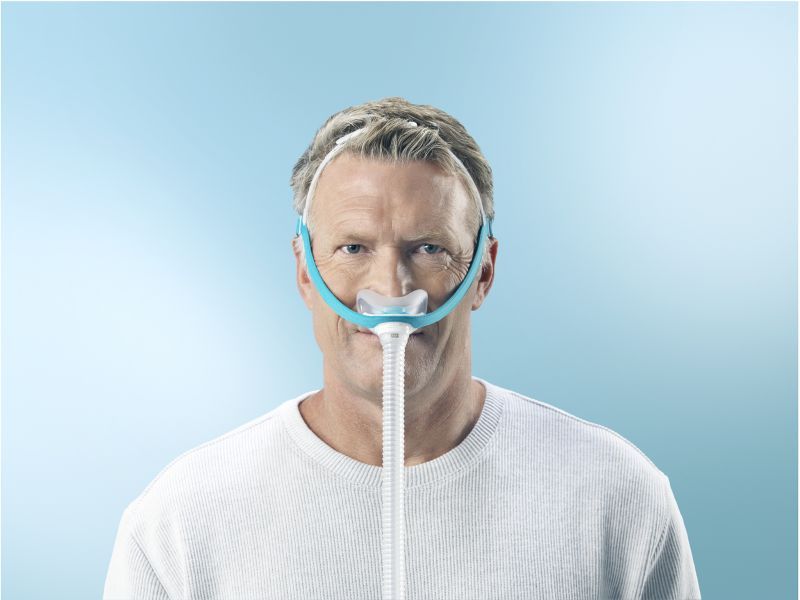 Un homme portant un masque nasal avec raccord de tube.
