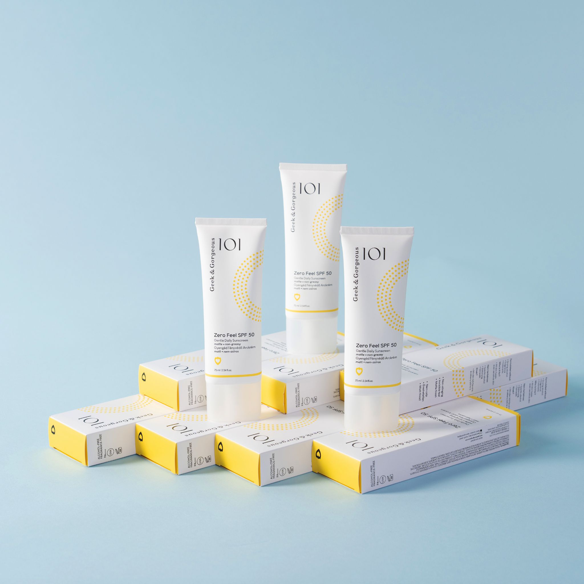 Trois tubes "Zero Feel SPF 50" sur boîtes. Accents jaunes. Marque : Geek & Gorgeous.