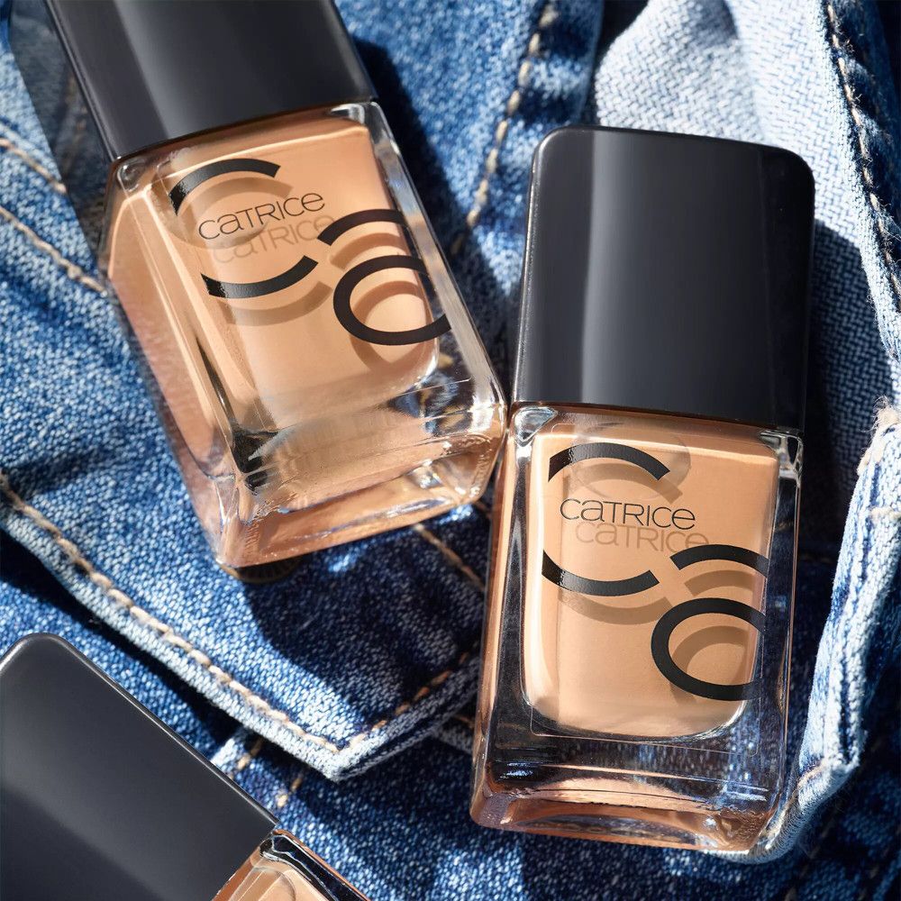 Deux flacons de vernis à ongles sur du tissu en jean. Catrice est écrit sur les flacons.