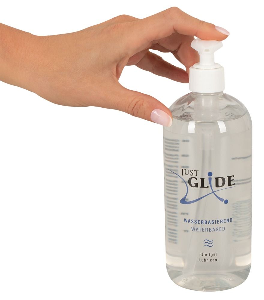 Hand die de pompdosering van een Just Glide glijmiddel fles indrukt, op waterbasis.