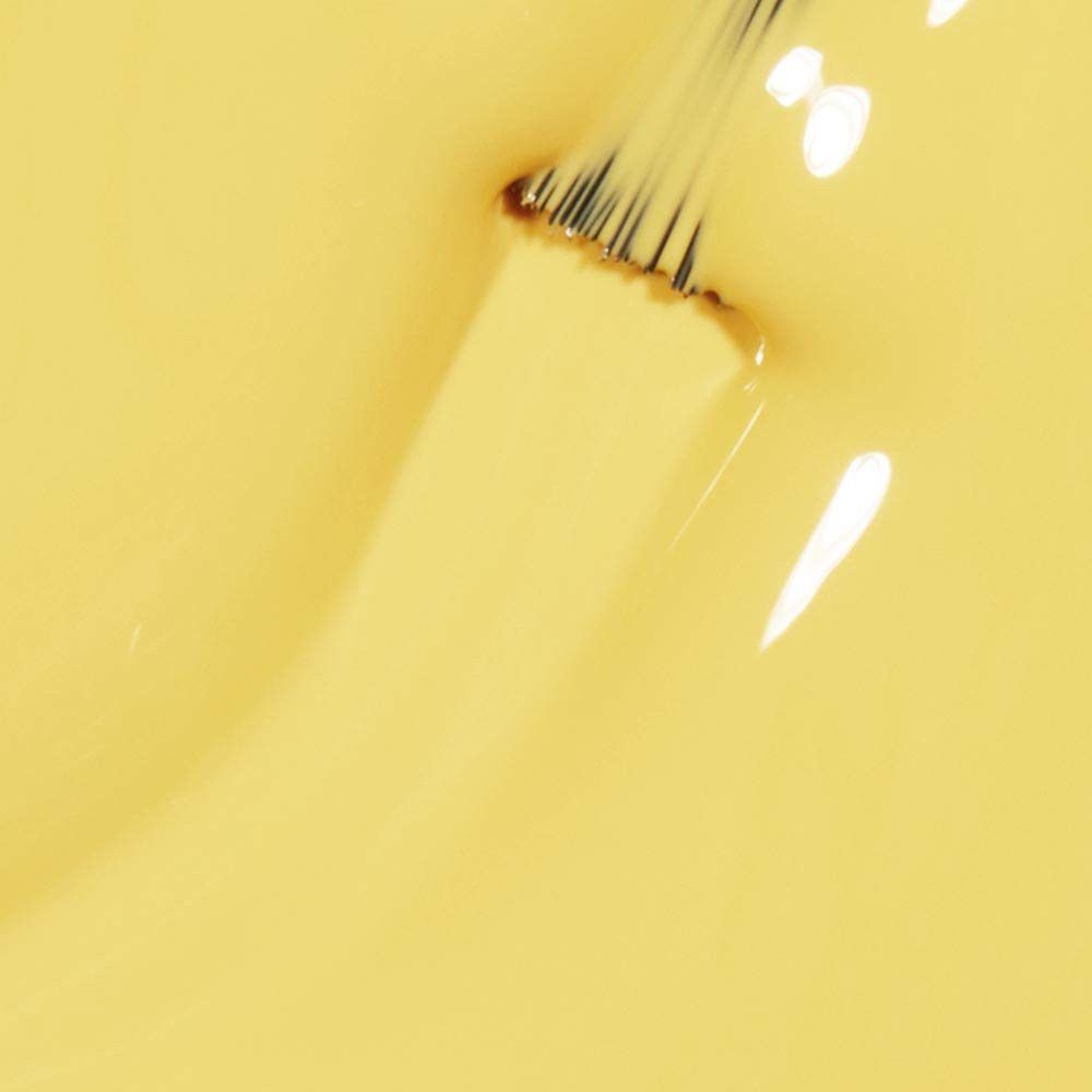 Gele nagellak met penseel. Close-up, penseel in lak gedoopt.