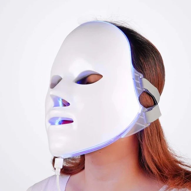 Masque facial blanc sur un visage. Éclairage LED visible. Connexion par câble.