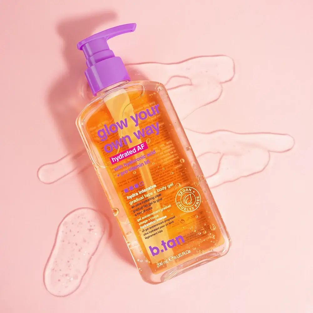 Flacon transparent avec pompe violette. Étiquette avec texte: glow your own way, hydrated AF, b.tan. Label vegan. Liquide.