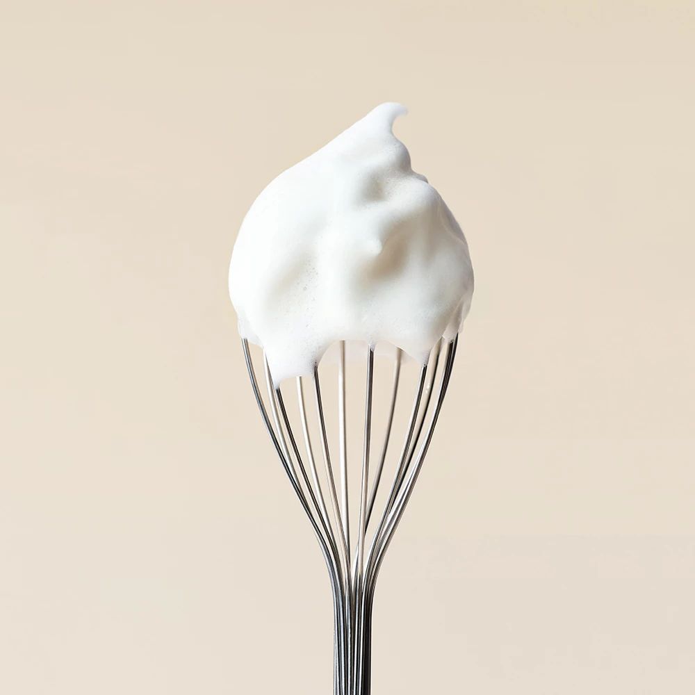 Un fouet avec une pointe de mousse nettoyante blanche.