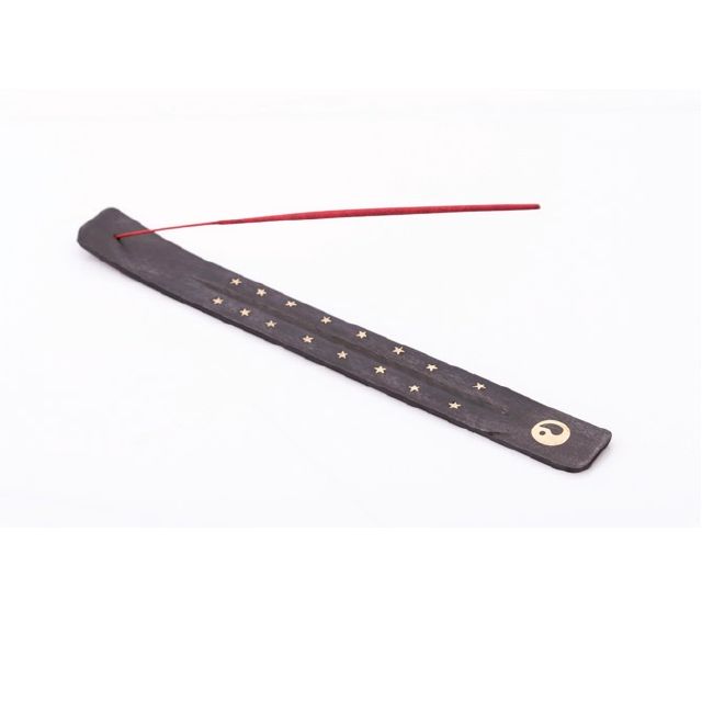 Porte-encens marron foncé avec étoiles et symbole Yin-Yang. Un bâton d'encens rouge est inséré.
