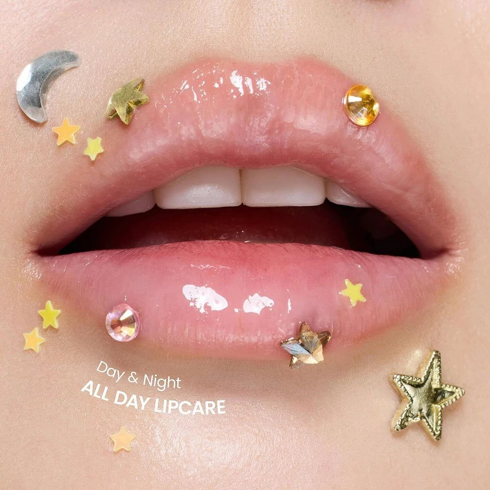 Lèvres brillantes ouvertes, décorées d'étoiles et d'un croissant. Texte: Day & Night ALL DAY LIPCARE.