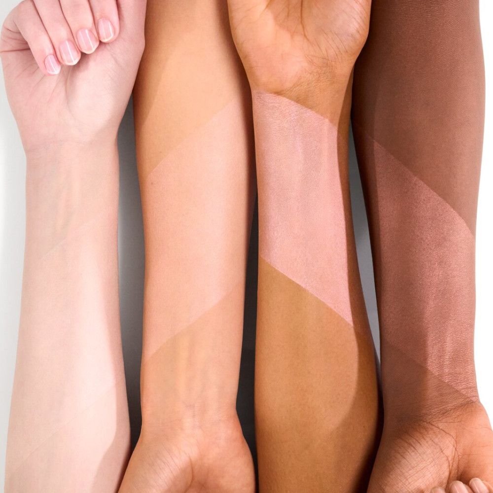 Armen met aangebrachte primer. Vier armen met verschillende huidtinten waarop primer is aangebracht.