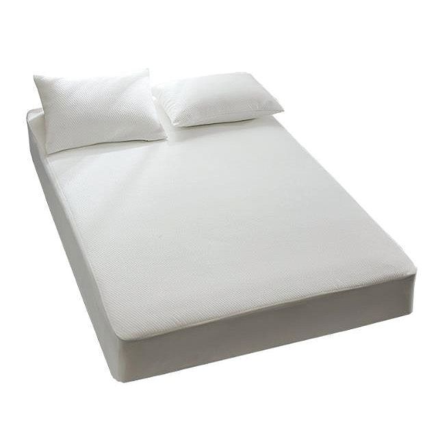 Wit hoeslaken op een bed met twee kussens. Het laken bedekt de matras.