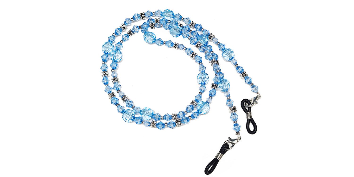 Cordon à lunettes avec perles bleues et détails métalliques. Extrémités avec boucles pour branches de lunettes.
