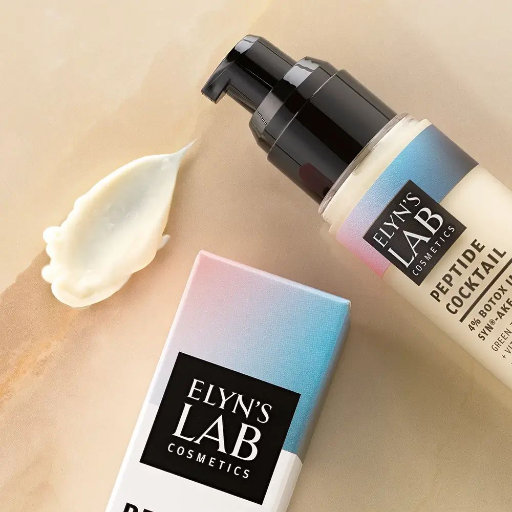 Gezichtsverzorgingstube met dispenser en crèmevlek. Verpakking met merklogo. Merk: Elyn's Lab.