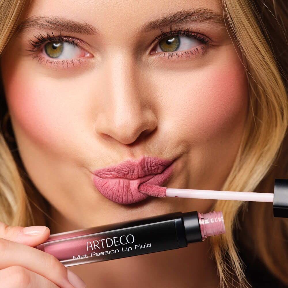 Vrouw met Artdeco Mat Passion Lip Fluid. Product en applicator zichtbaar. Lippenstift wordt aangebracht.