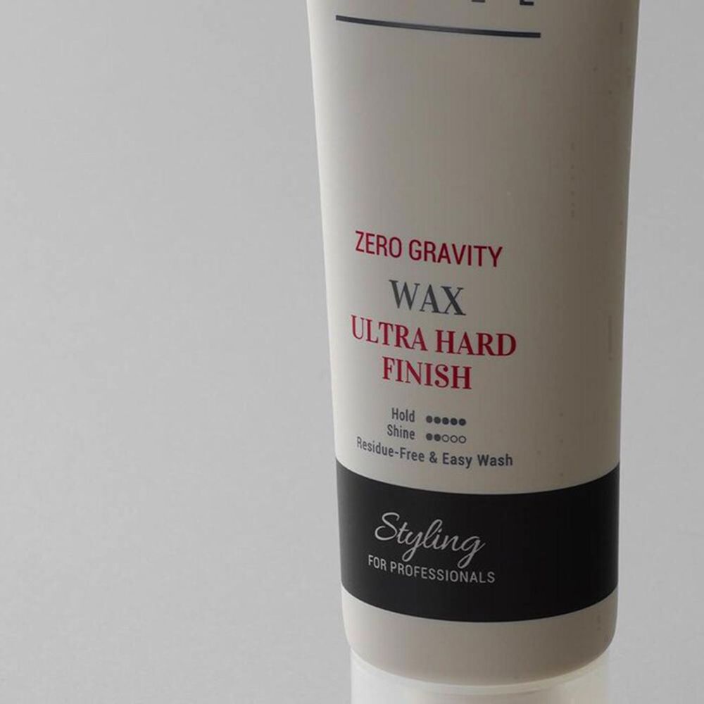 Beige tube met zwarte en witte tekst. Opschrift: CURLY SHYLL, Zero Gravity Wax, Ultra Hard Finish. Zwarte streep.