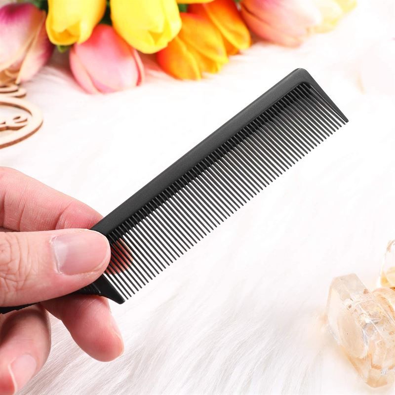 Peigne noir fin avec des dents fines et une pointe métallique intégrée.