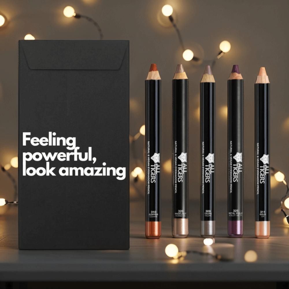 Cinq crayons pour les yeux à côté d'une enveloppe noire avec du texte. Crayons de différentes couleurs, avec logo et nom du produit.