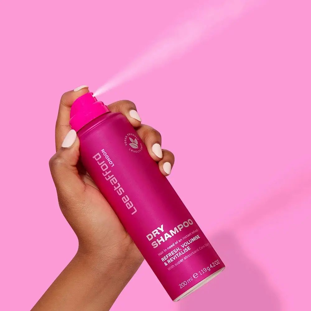 Hand houdt roze Lee Stafford London Dry Shampoo fles. Spray zichtbaar. Vegan, dierproefvrij. 200ml.
