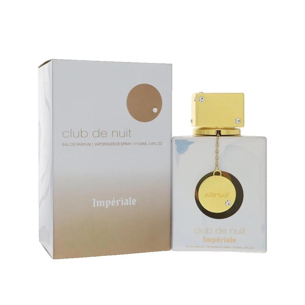 Parfumfles en verpakking. Vierkante fles, helder, gouden dop. Witte verpakking met gouden cirkel en tekst.