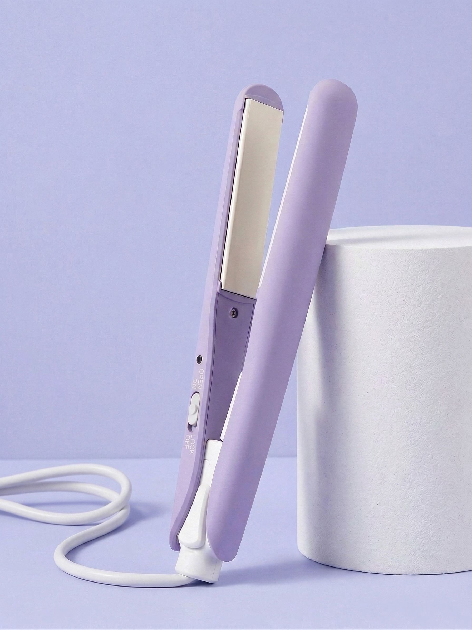 Lisseur violet avec cordon blanc, debout à côté d'un cylindre blanc.