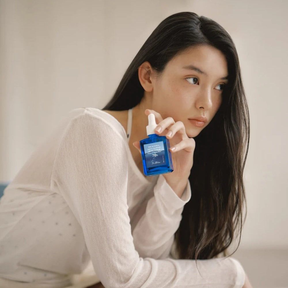 Femme tenant une bouteille de Dr. Althea Aqua Marine Deep Serum.