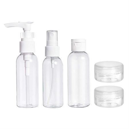 Ensemble de cinq flacons de voyage transparents : trois flacons pulvérisateurs et deux pots.