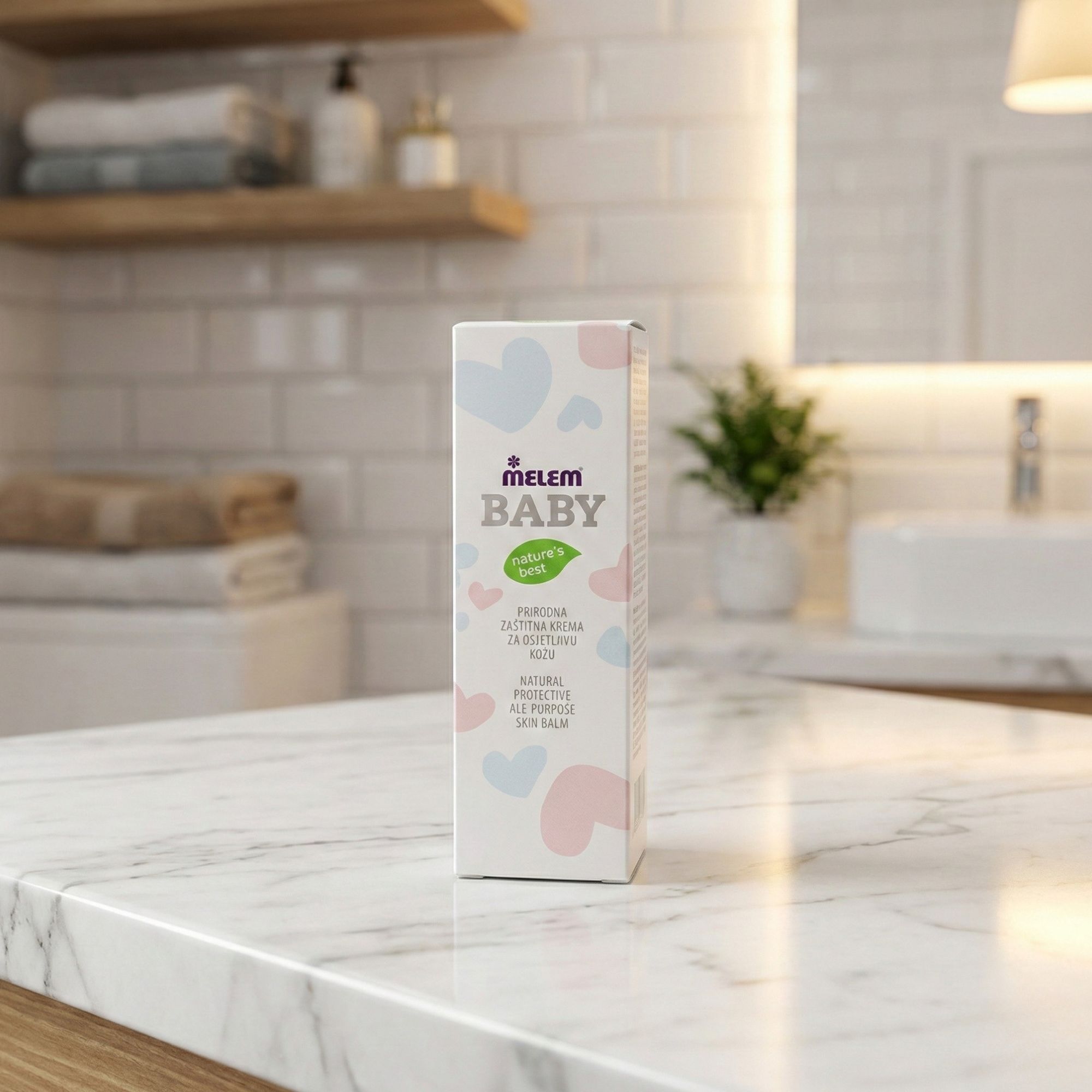 Boîte "Melem Baby" sur marbre. Texte : "Natural Protective All-Purpose Skin Balm". Arrière-plan salle de bain.
