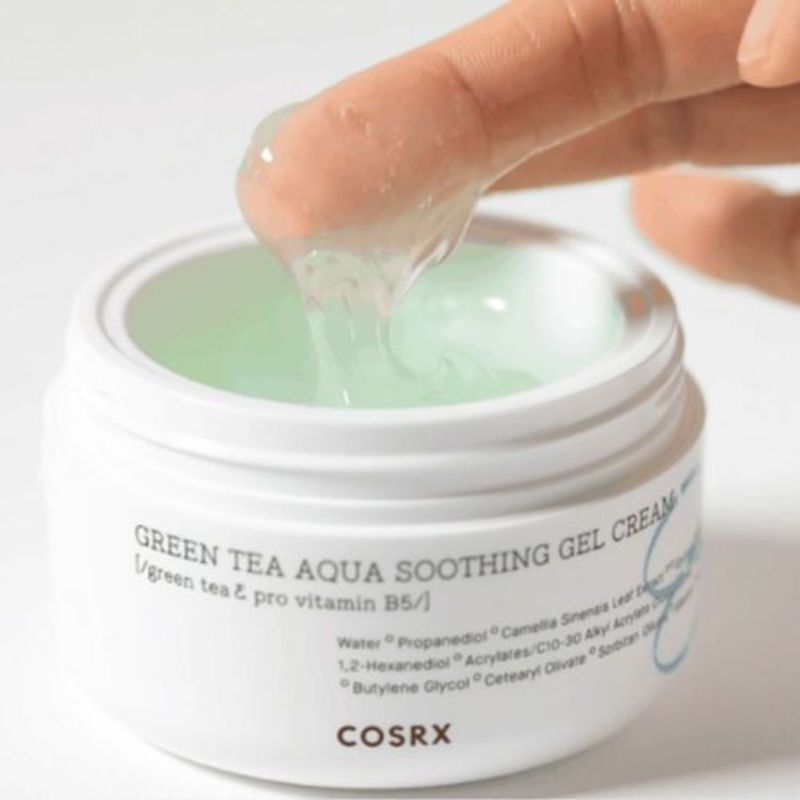 Witte pot met groen-gelachtig product. Vinger raakt de gel. Opschrift 'Green Tea Aqua Soothing Gel Cream' en 'COSRX'.