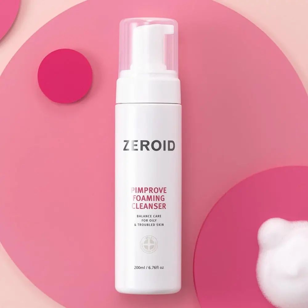 Flacon blanc ZEROID Pimprove Foaming Cleanser avec pompe. Nom du produit et texte. Sur fond rose. Mousse.