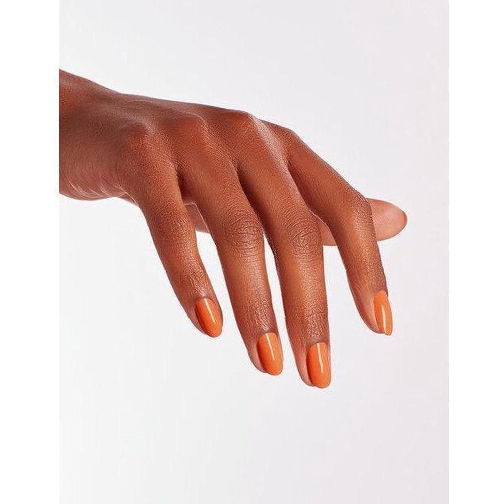Main avec ongles vernis. Ongles vernis en orange brillant.